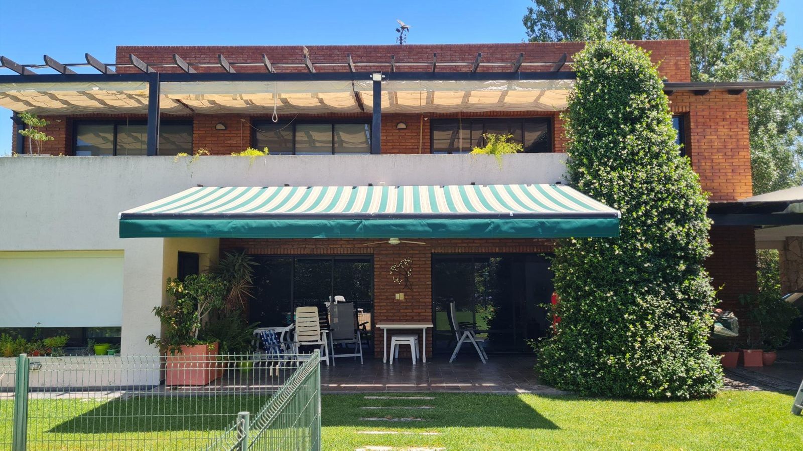 Toldo de brazos extensibles en casa